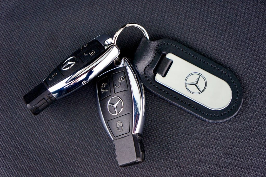 pexels photo 16714035 Close-up of Mercedes-Benz car keys with a leather keychain on dark fabric background.